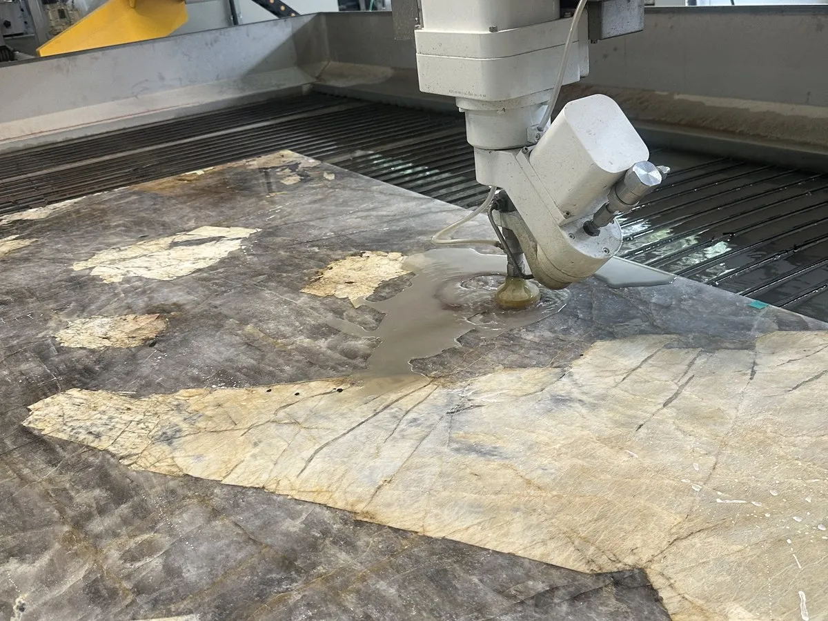 Vodní paprsek (waterjet) při řezání kamenné desky — výřezy a otvory na zakázku